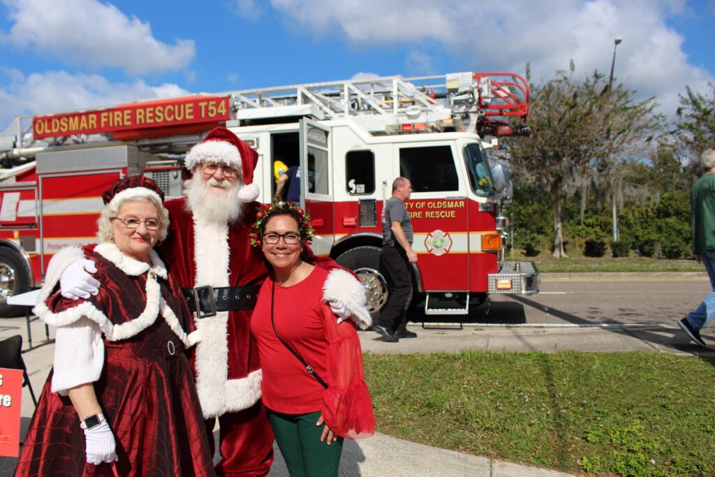 Santa, Mrs. Clause, and Kathy Wallace at Spread the Love - Oldsmar Cares Kids's Christmas and Toy Giveaway